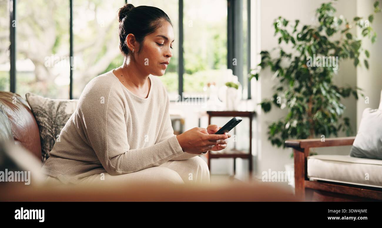 Couch, Tippen und reife Frau mit Telefon, um sich zu entspannen, Nachrichten zu überprüfen und im Internet zu surfen. Soziale Medien, Videos ansehen oder Person mit Mobiltelefon Stockfoto