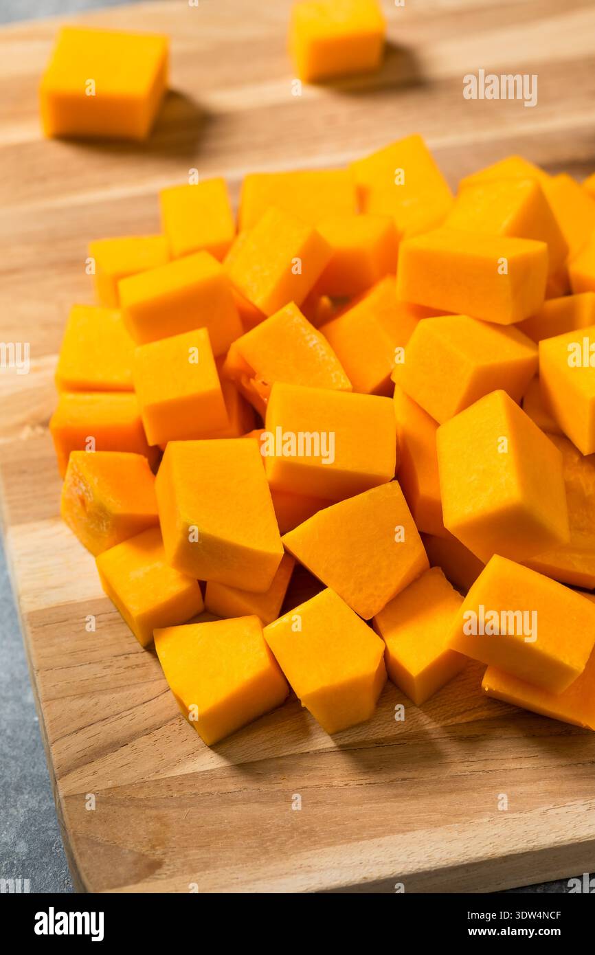 Biologisch gewürfelter Butternusskürbis auf einem Schneidebrett Stockfoto