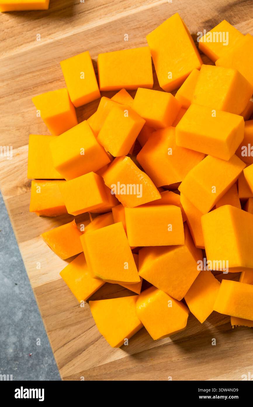 Biologisch gewürfelter Butternusskürbis auf einem Schneidebrett Stockfoto