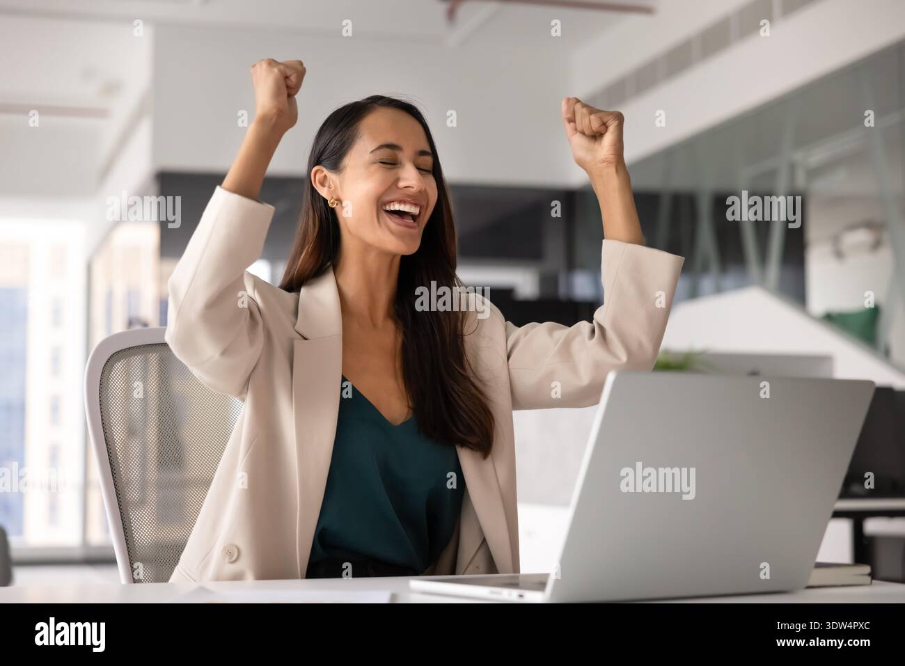 Eine Frau, die tolle Nachrichten liest, ihre Fäuste in feierlicher Geste hochhebt Stockfoto