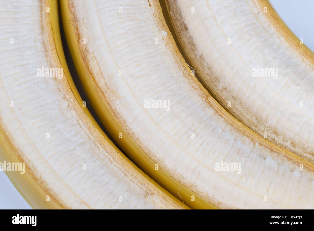 Reife, geschälte Bananen-Makrostruktur mit zarten Fasern und feuchtem Fleisch, minimalistische Komposition mit weichem natürlichem Licht und neutraler Kulisse, taktvoll Stockfoto