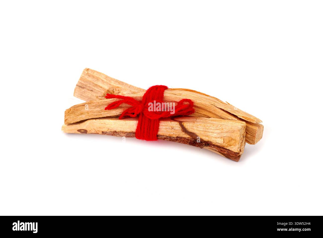 Ein kleines Bündel Sandelholzstäbchen, das mit rotem Garn gebunden ist, liegt auf weißem Hintergrund Stockfoto