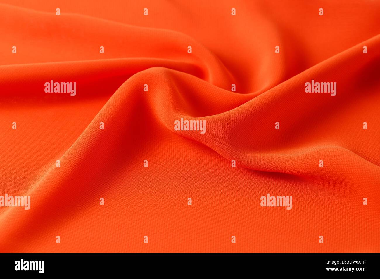 Abstrakter orangefarbener Hintergrund. Seidenstoff drapiert Stockfoto