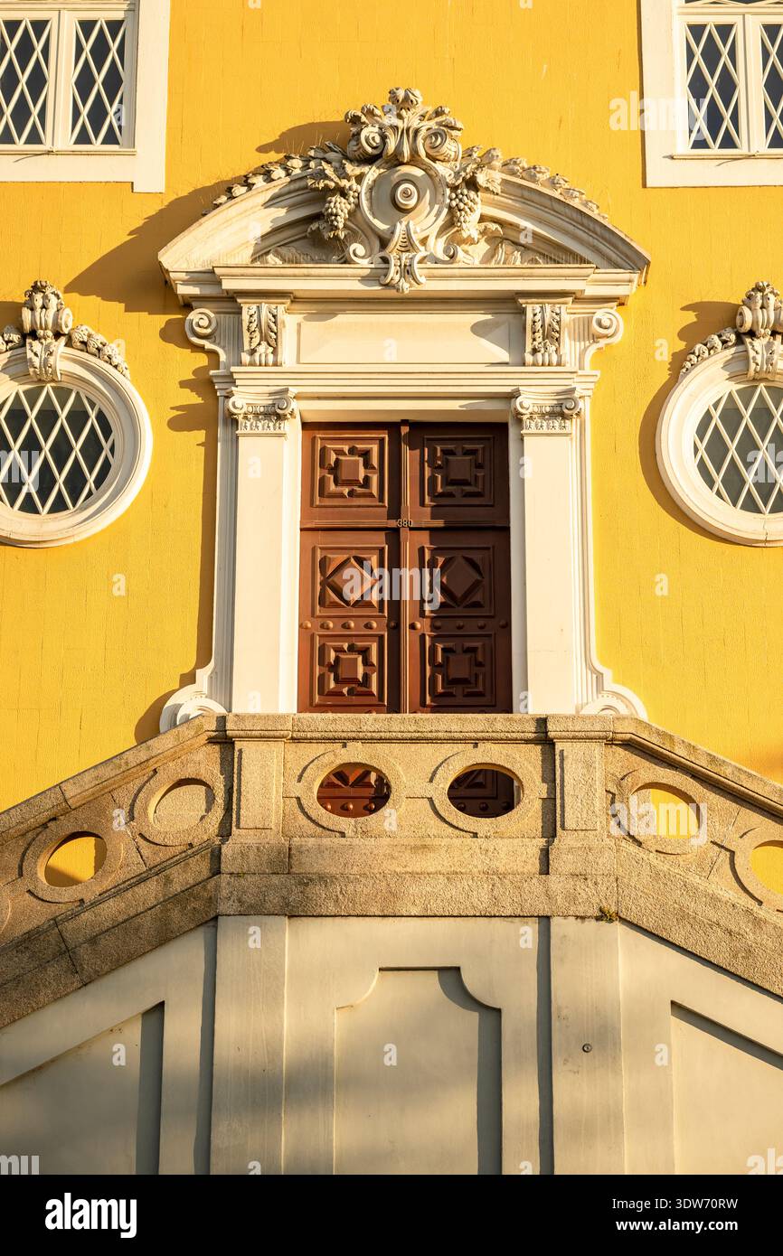 Nahaufnahme eines kunstvollen Barockeingangs in einem historischen Gebäude in Porto, Portugal, mit dekorativer Holztür und komplizierten Steinschnitzen Stockfoto