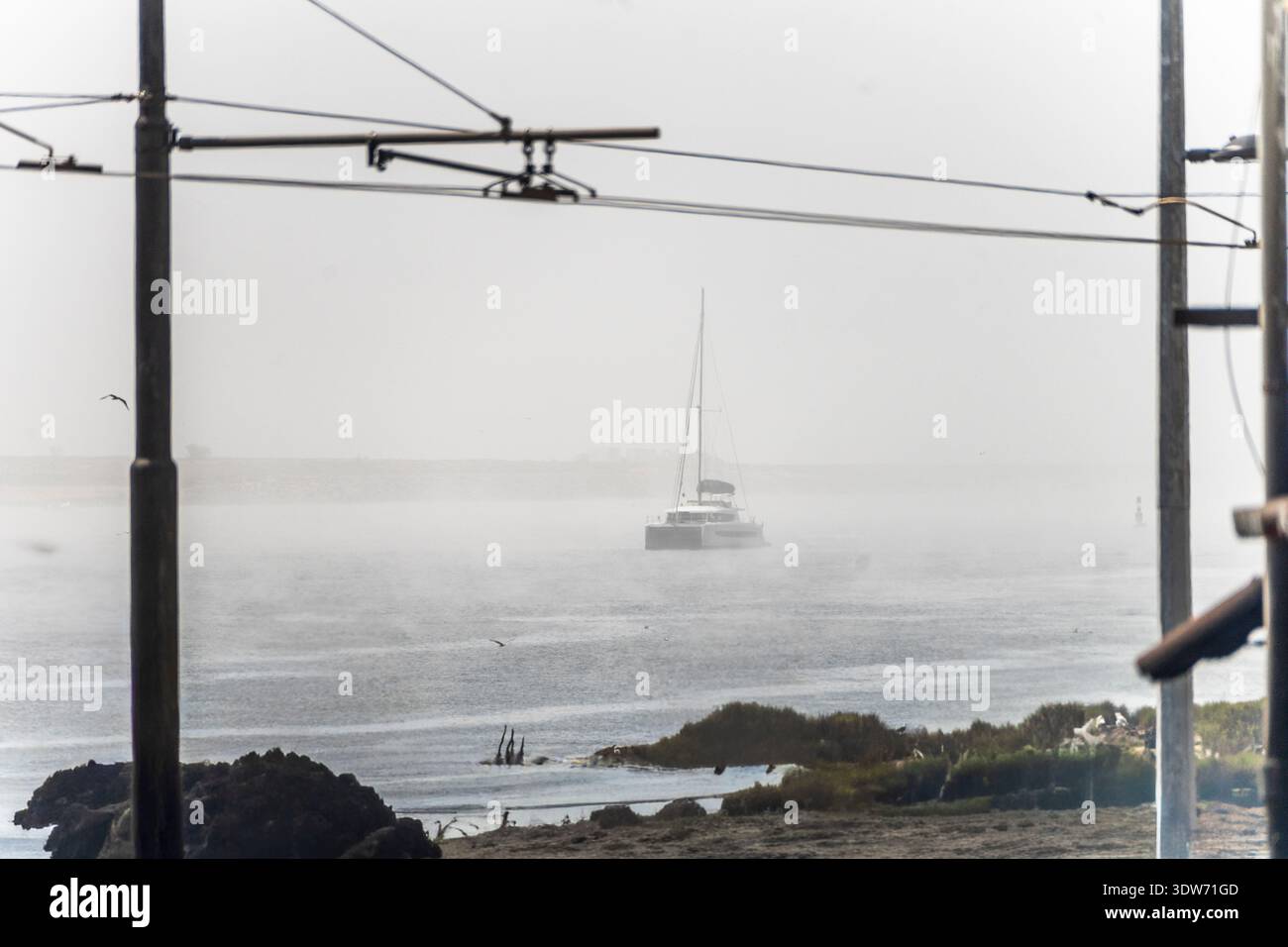 Nebel bedeckt Porto, während eine Yacht durch den Nebel erscheint und eine geheimnisvolle Szene schafft. Stockfoto