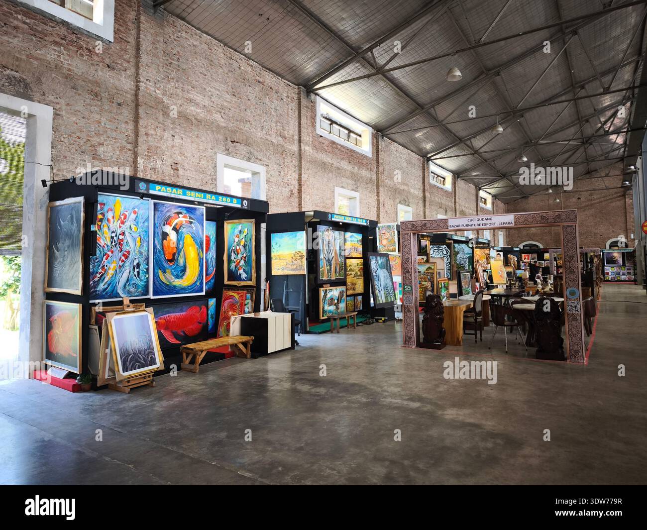 Eine Reihe von Ständen, die Gemälde und Kunstwerke auf einem Kunstmarkt in einem ehemaligen Zuckerfabrikgebäude verkaufen, das als Rastplatz an der Mautstraße genutzt wurde Stockfoto
