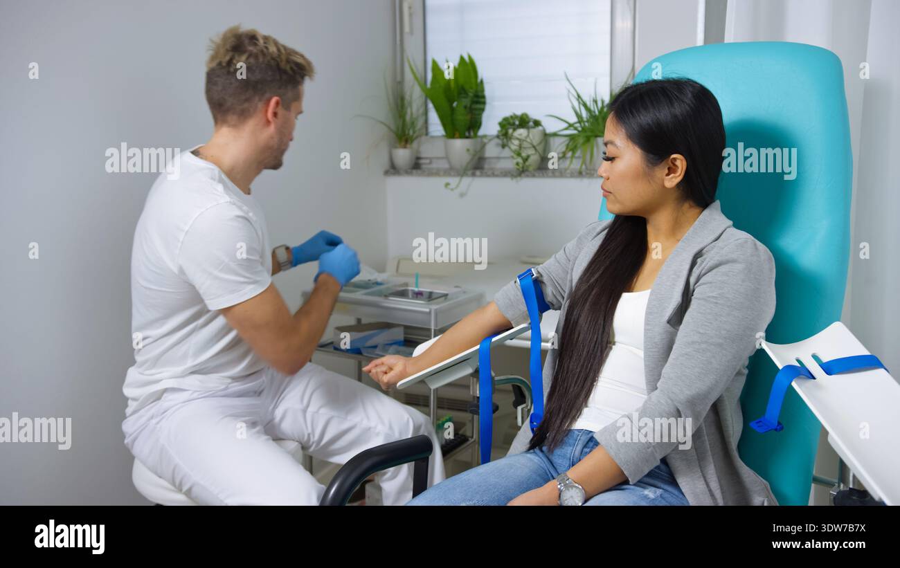 Medizinisches Fachpersonal entnimmt Blut von Patienten in einer modernen Klinik. Das Verfahren konzentriert sich auf Venenpunktion und Probenentnahme. Stockfoto