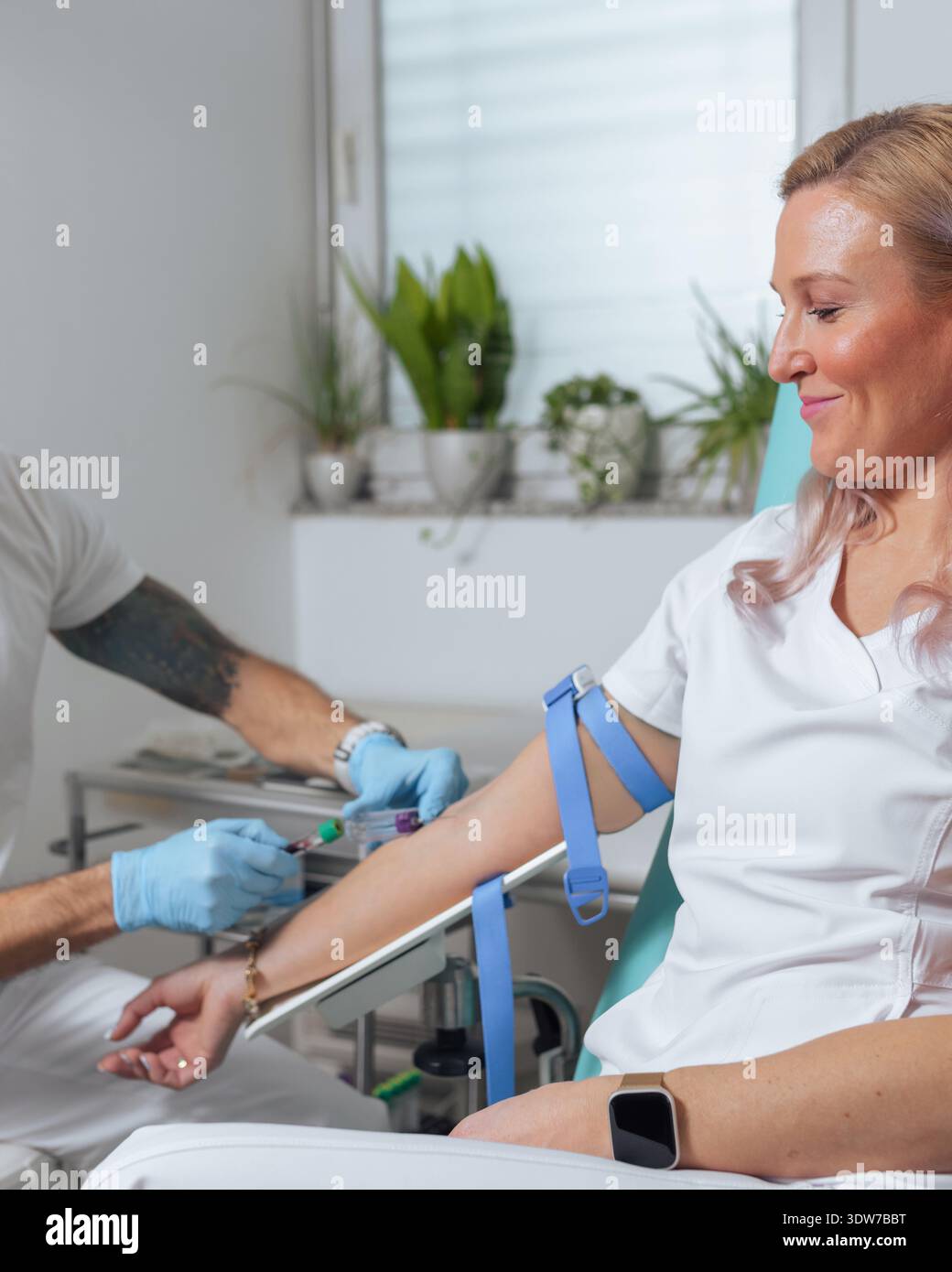 Ein medizinisches Fachpersonal führt eine Blutentnahme an einem Patienten in einer Klinik durch, um eine Blutprobe für Tests und Analysen zu entnehmen. Stockfoto