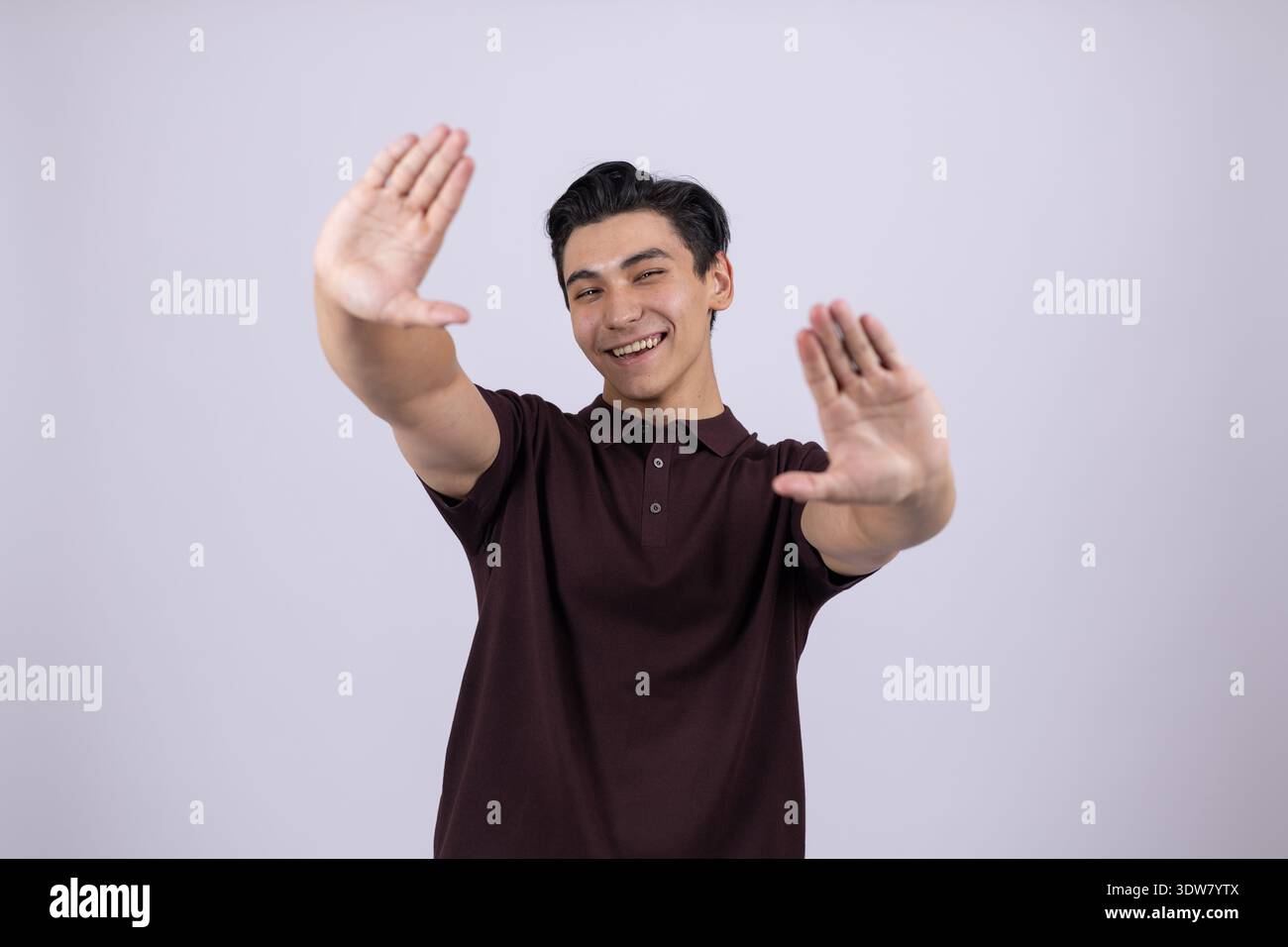 Mann in kastanienbraunem Poloshirt, der eine winkende Geste zeigt Stockfoto