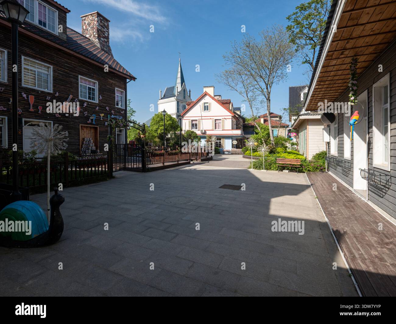 Eine gepflasterte Straße gesäumt von bunten Häusern und Geschäften im europäischen Stil, die eine charmante dörfliche Atmosphäre schaffen, die typisch für ein Resort oder Outlet Mall ist. Stockfoto