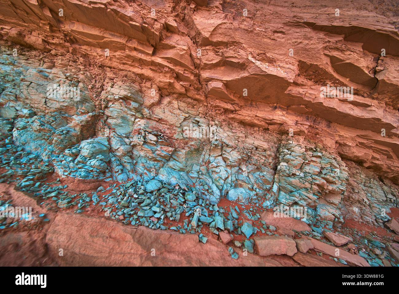 Farbenfrohe Felsformation mit grünen Mineralablagerungen und erodierter Steinstruktur Stockfoto