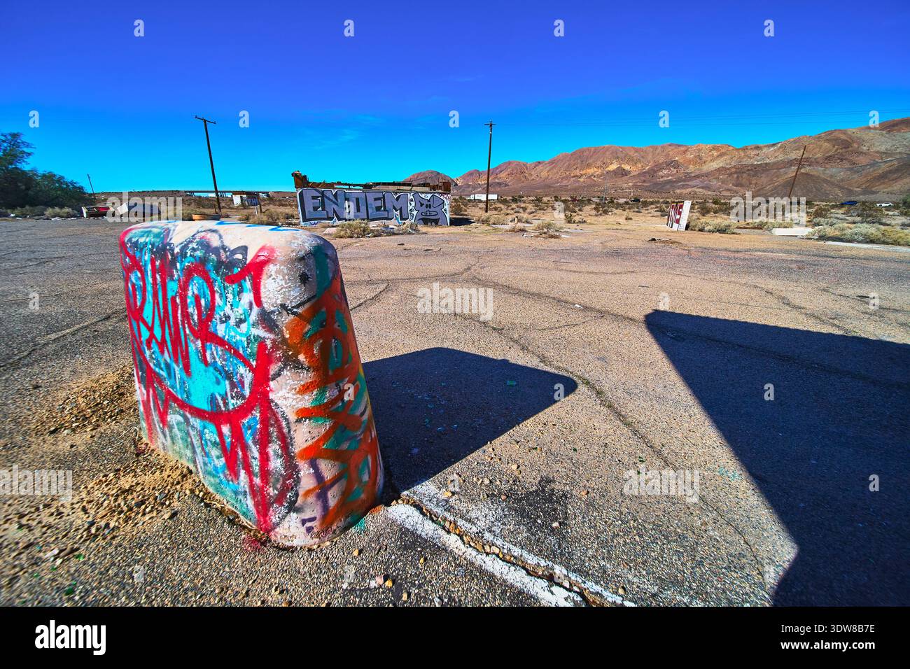 Graffiti Betonbarriere verlassenes Grundstück und Wüstenberge in Yermo Kalifornien Stockfoto