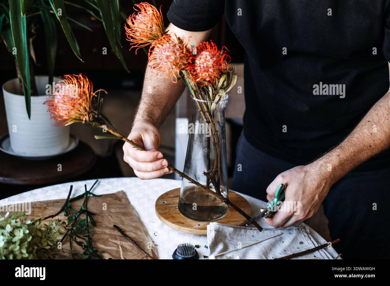 Nahaufnahme der Hände, die sich mit Blumenarrangements beschäftigen, um geistiges Wohlbefinden und achtsame Präsenz durch kreative botanische Interaktion zu fördern Stockfoto