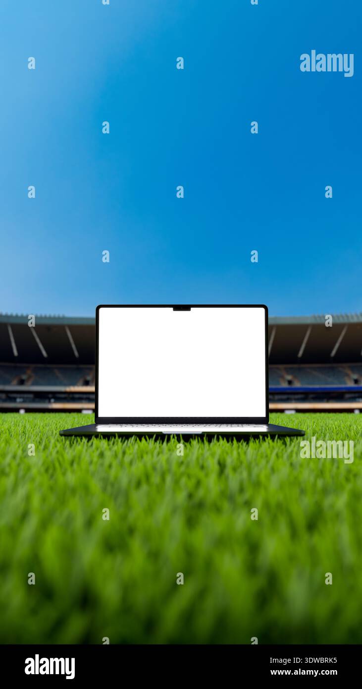 Laptop mit leerem Bildschirm über dem Grasfeld in einem Fußball- und Fußballstadion. Leeres Anzeigegerät für Modell in 8k – hochauflösendes 3D-Rendering. Vertikal Stockfoto