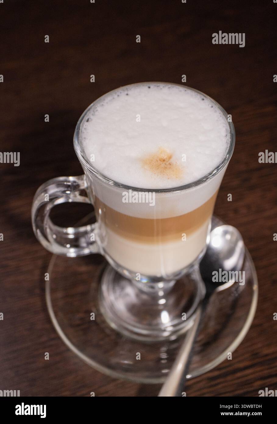 Latte in einer Glasschale auf einem Holztisch Stockfoto