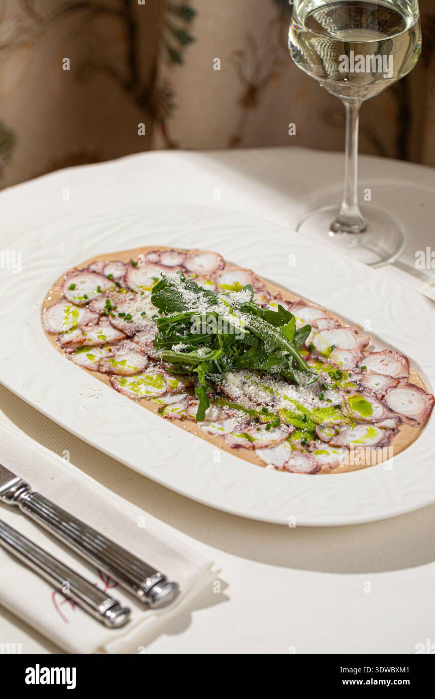 Octopus carpaccio mit Rucola und Parmesan Stockfoto