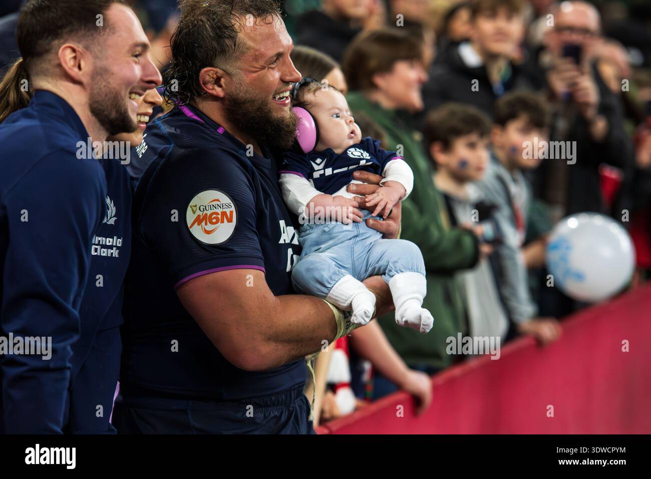 Cardiff, Großbritannien, 21. Februar 2026 Schottland-Requisite Pierre Schoeman hält ein Baby und lässt sich nach dem Spiel gegen Wale mit dem jungen Fan fotografieren Stockfoto