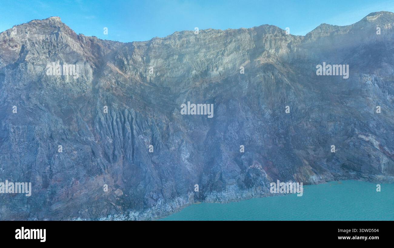 Aus der Vogelperspektive auf die Felsenklippe am Kawah Ijen Vulkan mit türkisfarbenem Schwefelwassersee. Panoramablick auf den Vulkan Kawah Ijen in Ost-Java, Indonesien. Natur l Stockfoto