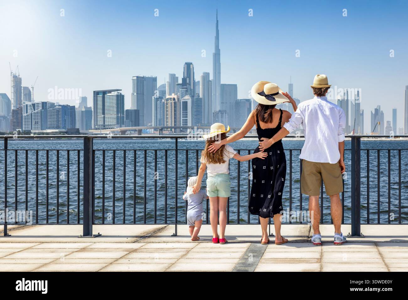 Eine vierköpfige Touristenfamilie schaut während ihres Stadturlaubs gemeinsam auf die Skyline von Dubai, den Vereinigten Arabischen Emiraten Stockfoto