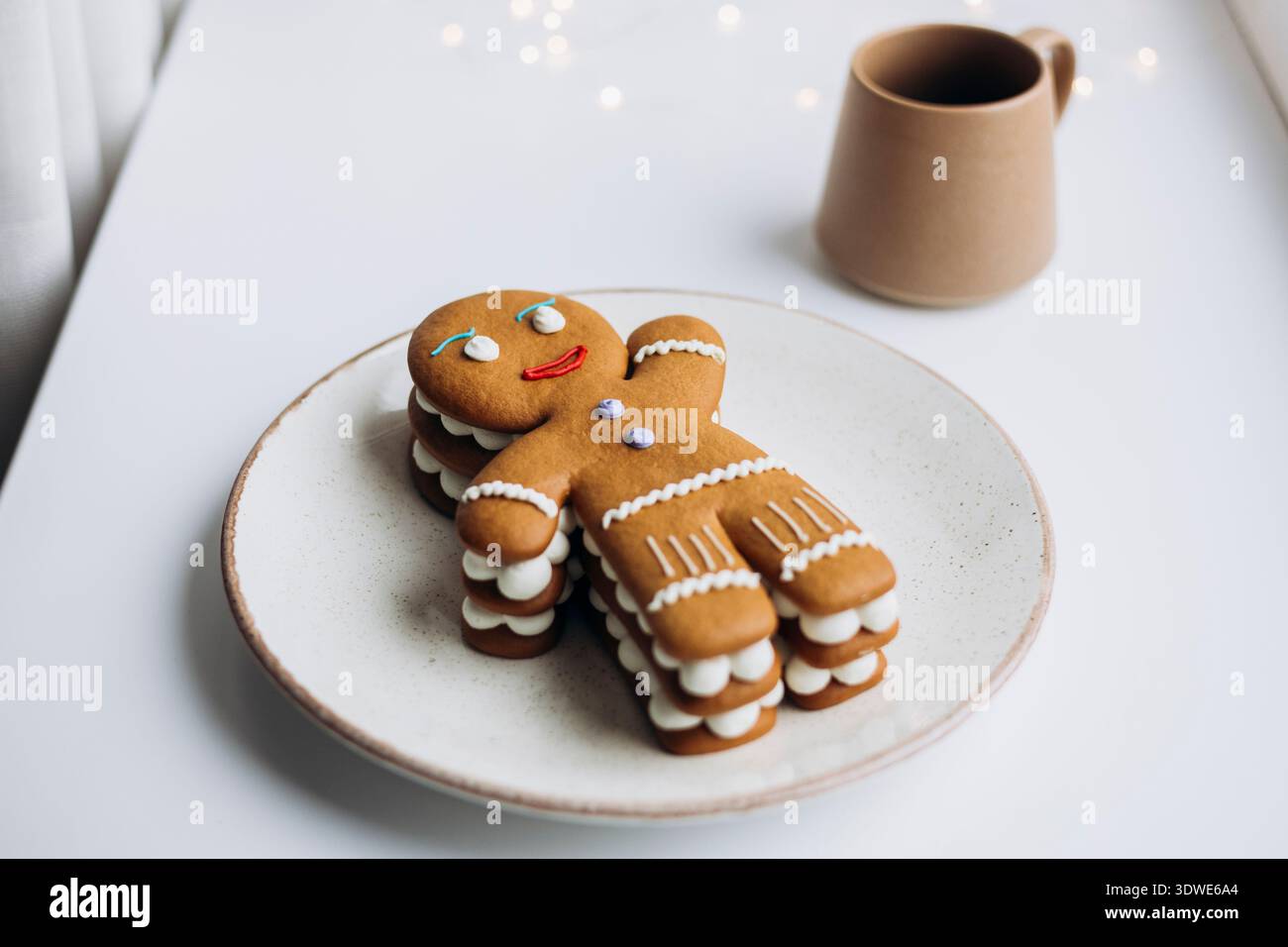 Dekorierter Lebkuchenmann-Kuchen auf einem Teller, perfekt für die Weihnachtszeit. Der Kuchen ist kreativ gestapelt und dekoriert, was den festlichen Urlaub einfängt Stockfoto