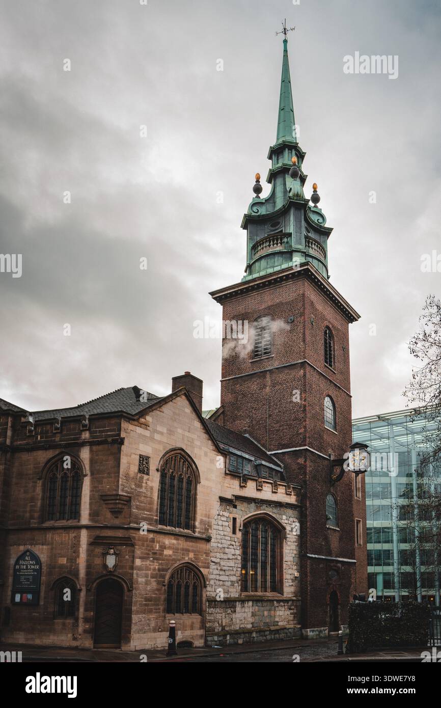 London, Großbritannien - 30. Januar 2026: Blick auf die historische All Hallows-by-the-Tower Kirche, deren alter Stein im Kontrast zum modernen Glasbogen steht Stockfoto