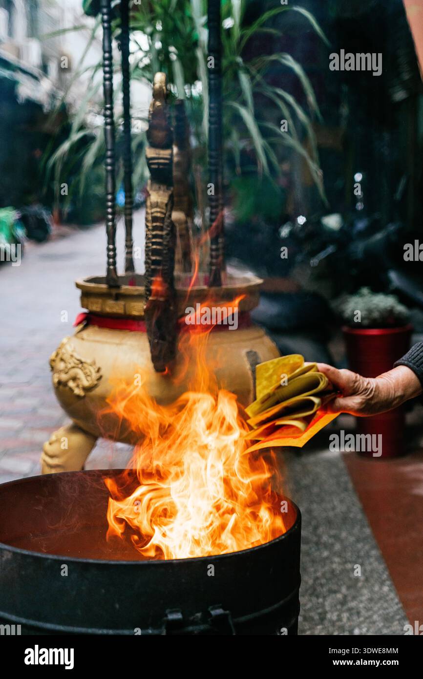 Eine Person verbrennt in Taiwan Joss-Papier, ein Ritual, um Verstorbene oder Gottheiten zu ehren, das es Geistern und Ahnen erlaubt, im Nachhinein Waren oder Gefälligkeiten zu empfangen Stockfoto