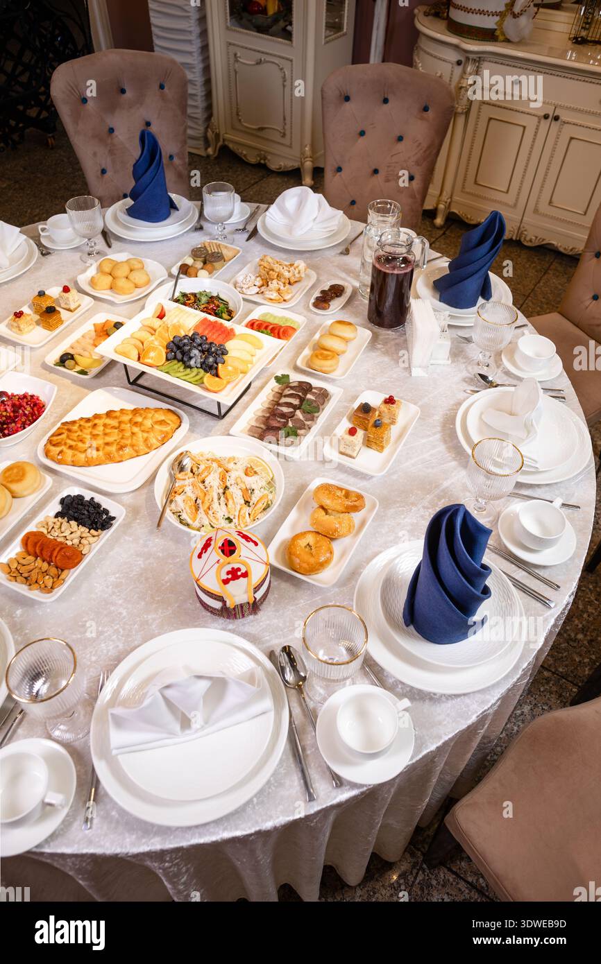Runder Banketttisch mit Vorspeisen, Obst und Desserts Stockfoto