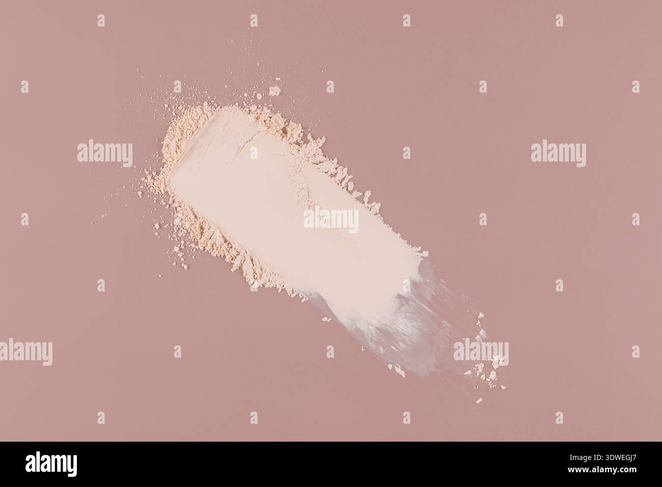 Ein kompaktes Pulver, das elegant auf einer glatten beigen Oberfläche verteilt wird. Die Textur und die feinen Partikel des kosmetischen Pulvers vermischen sich nahtlos und zeigen es Stockfoto