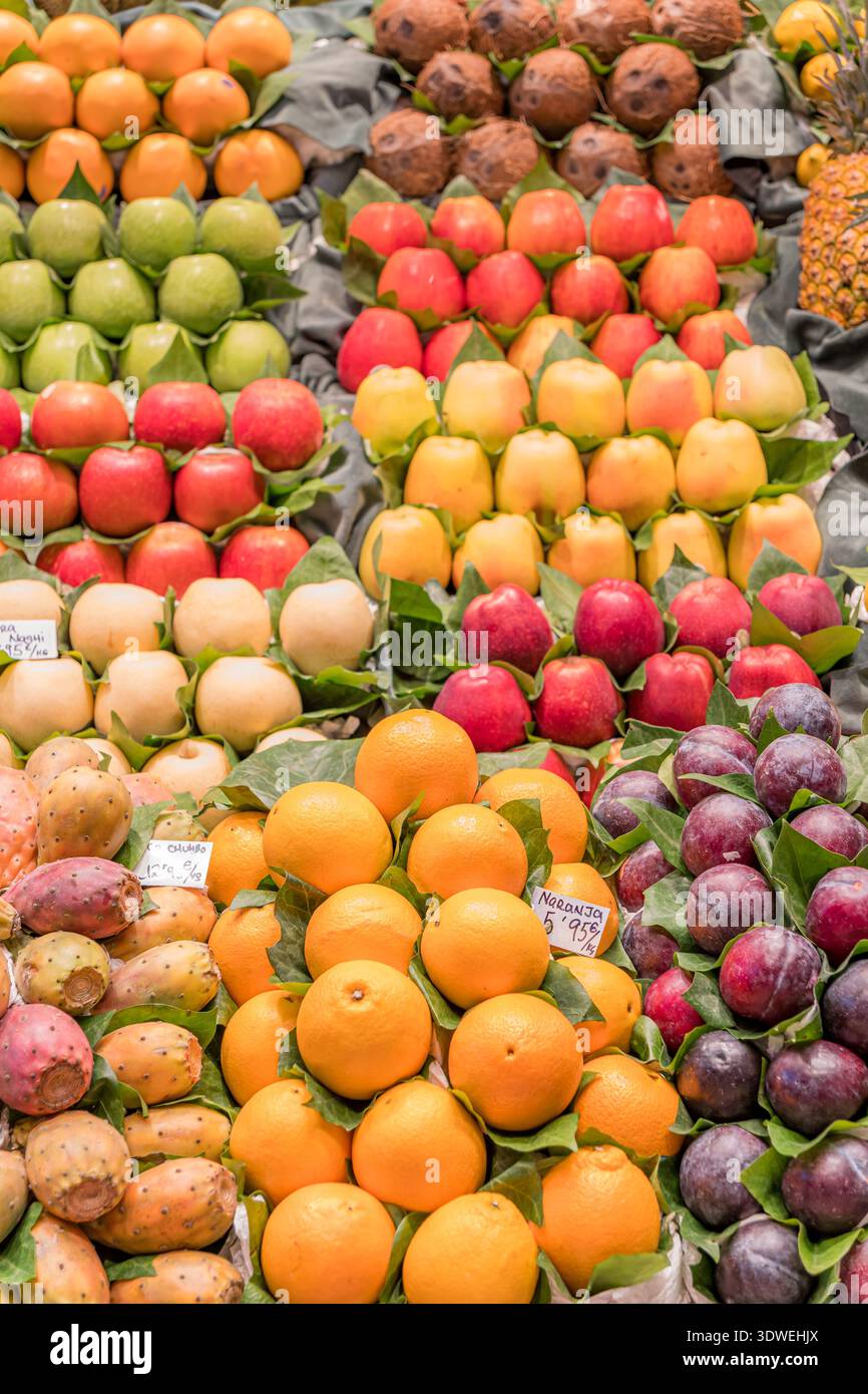 Eine lebhafte Präsentation von verschiedenen Früchten an einem Marktstand zeigt eine reiche Vielfalt an Farben und Texturen. Frische Orangen, Äpfel, Birnen und Pflaumen sind AR Stockfoto