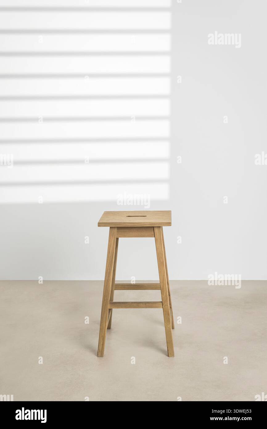 Ein eleganter Holzstuhl mit minimalistischem Design, perfekt für moderne Innenräume. Die Oberfläche aus Naturholz sorgt für Wärme und Eleganz und ist somit ideal für den Concept Stockfoto