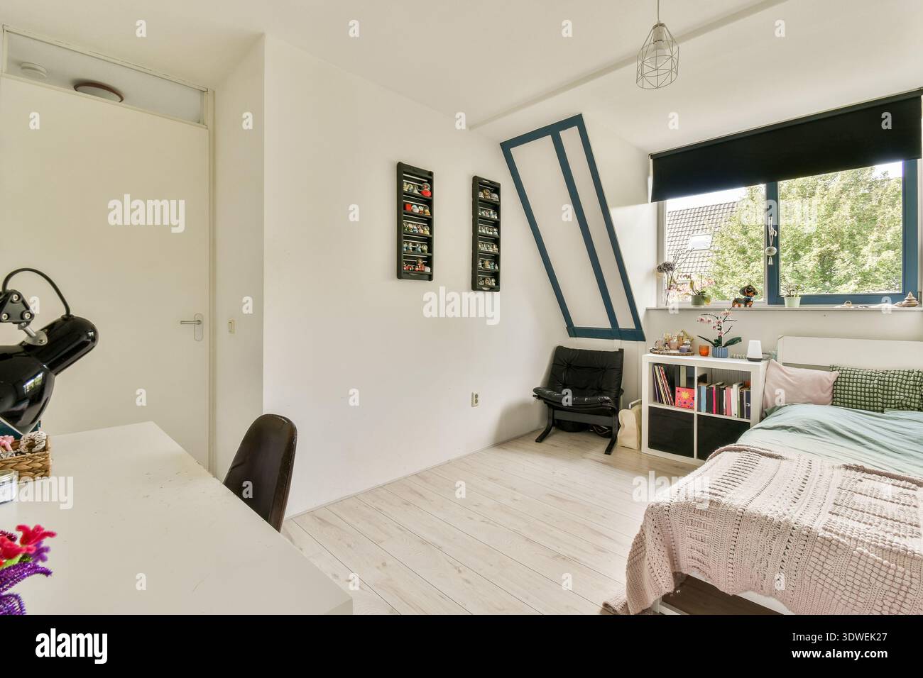Ein gemütliches, stilvolles Schlafzimmer mit einer ruhigen Farbpalette, modernen Möbeln und natürlichem Licht unterstreichen das minimalistische Design. Perfekt zum Entspannen und Co Stockfoto