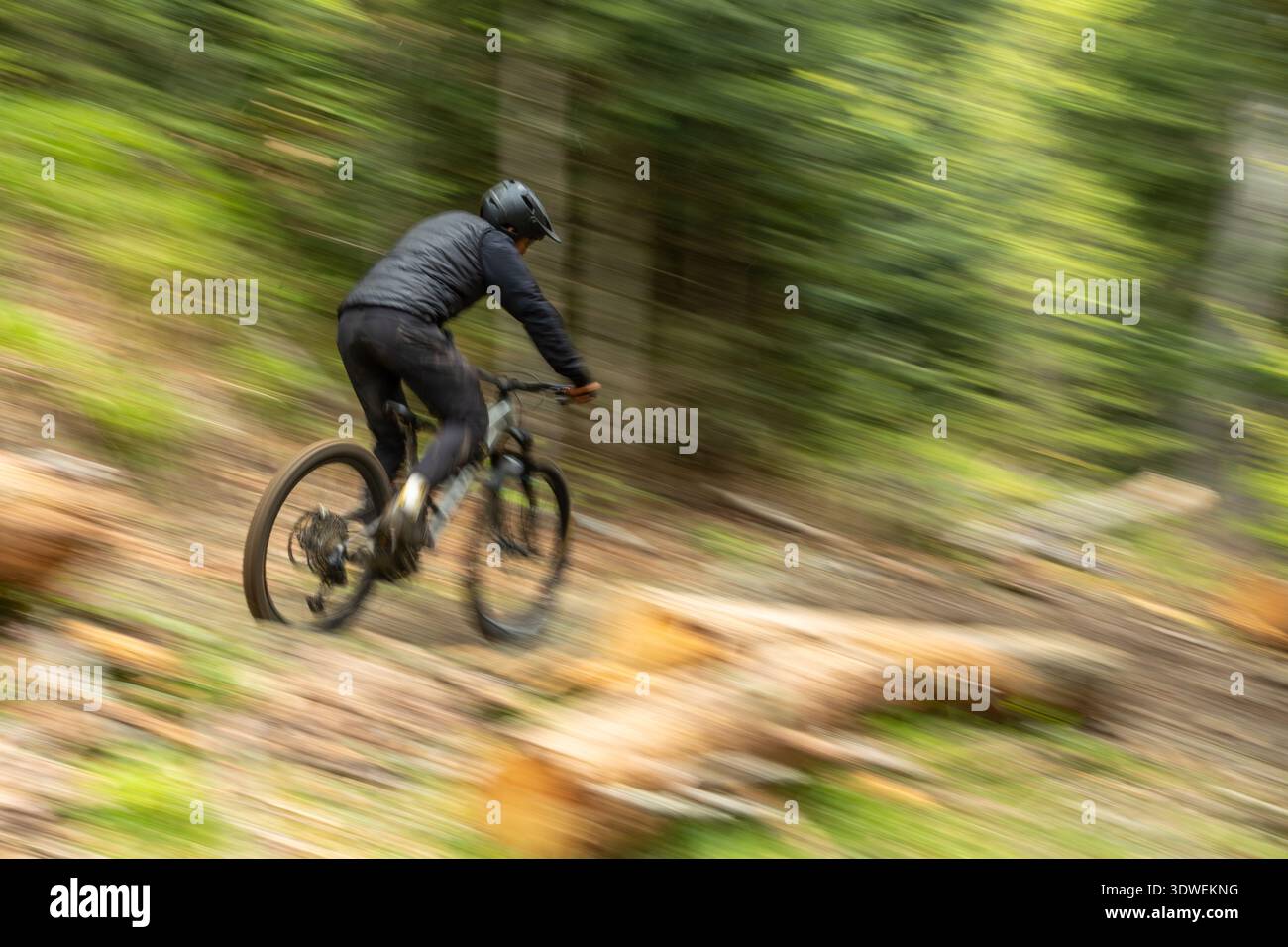 Ein Mann navigiert mit einem Mountainbike auf den zerklüfteten Wegen in den Pyrenäen und zeigt dynamische Bewegungen und Abenteuer in einer wunderschönen natürlichen Umgebung Stockfoto
