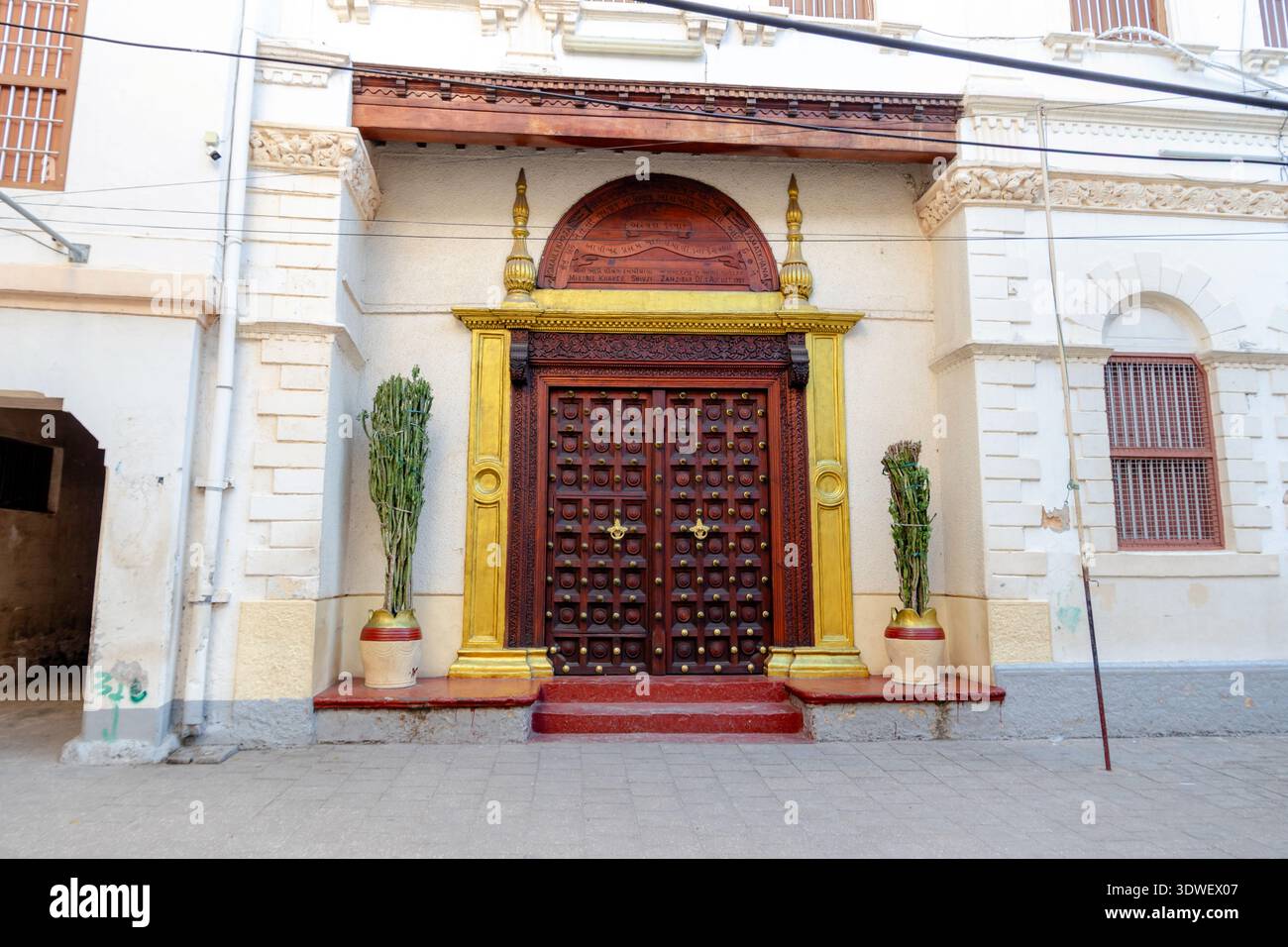 Ein aufwändig gestaltetes historisches jüdisches Tor in Stone Town, Sansibar, mit lebendigen Holzmustern und traditioneller Handwerkskunst. Flankiert von Orn Stockfoto