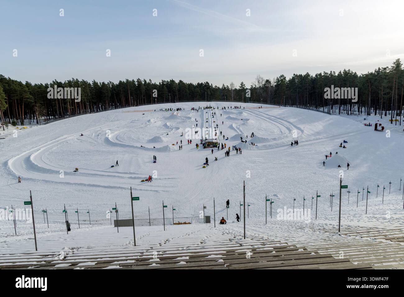 Die Leute genießen Snowtubing und Winteraktivitäten in der Arena Mezaparks Great Bandstand in Riga Lettland. Blick aus einem hohen Winkel auf das schneebedeckte Erholungsgebiet. Stockfoto