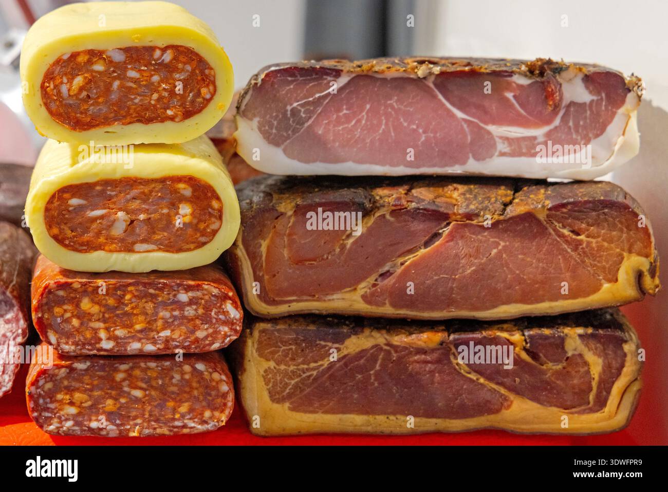 Hackfleisch aus Schweinefleisch Kulen-Würstchen mit rotem Paprika und einem Stapel Räucherschinken Stockfoto