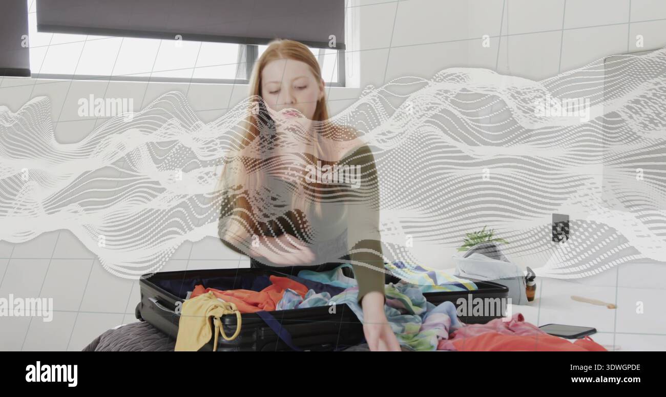 Eine Frau, die im gefliesten Zimmer mit Olivendecke auf dem Bett lag, handelte den Koffer mit weißer Welle Stockfoto