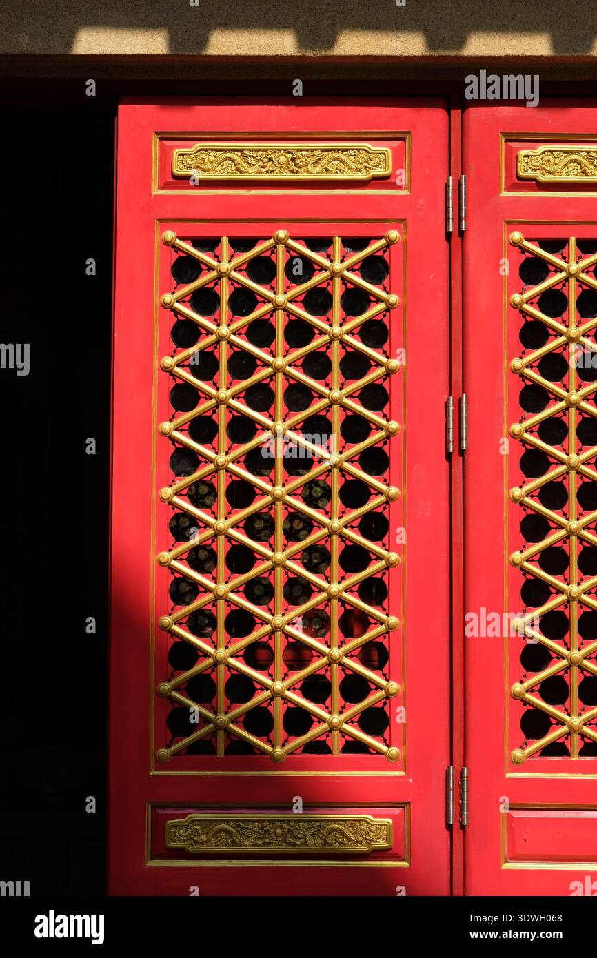 Komplizierte rote und goldene chinesische Tempeltüren mit Drachenmotiv und geometrischem Gitter Stockfoto
