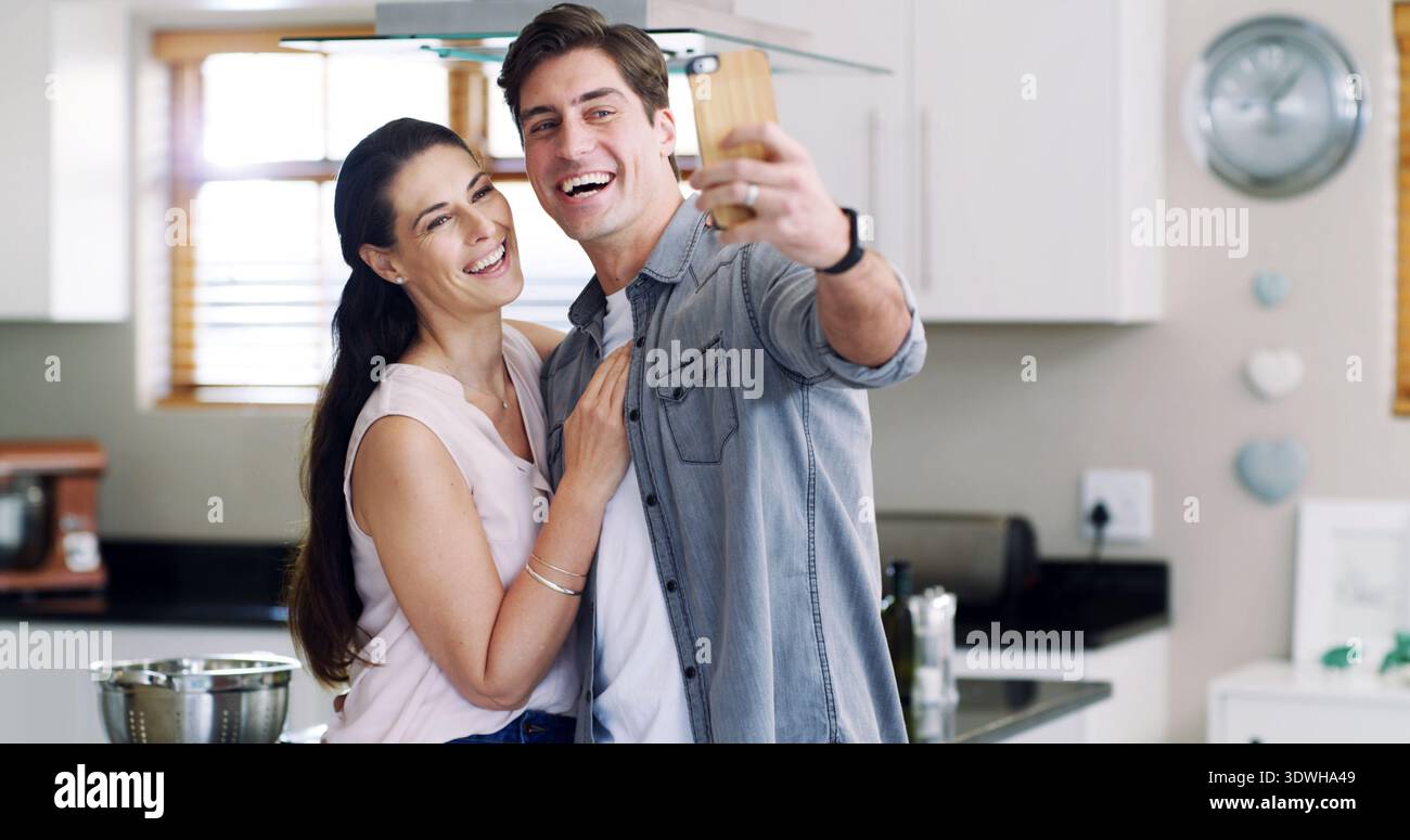 Fotos, Lächeln und Paare mit Selfie in der Küche, Social Media Post und Momente zur Erinnerung festhalten. Verbindung, Bindung und Leute mit Lachen Stockfoto