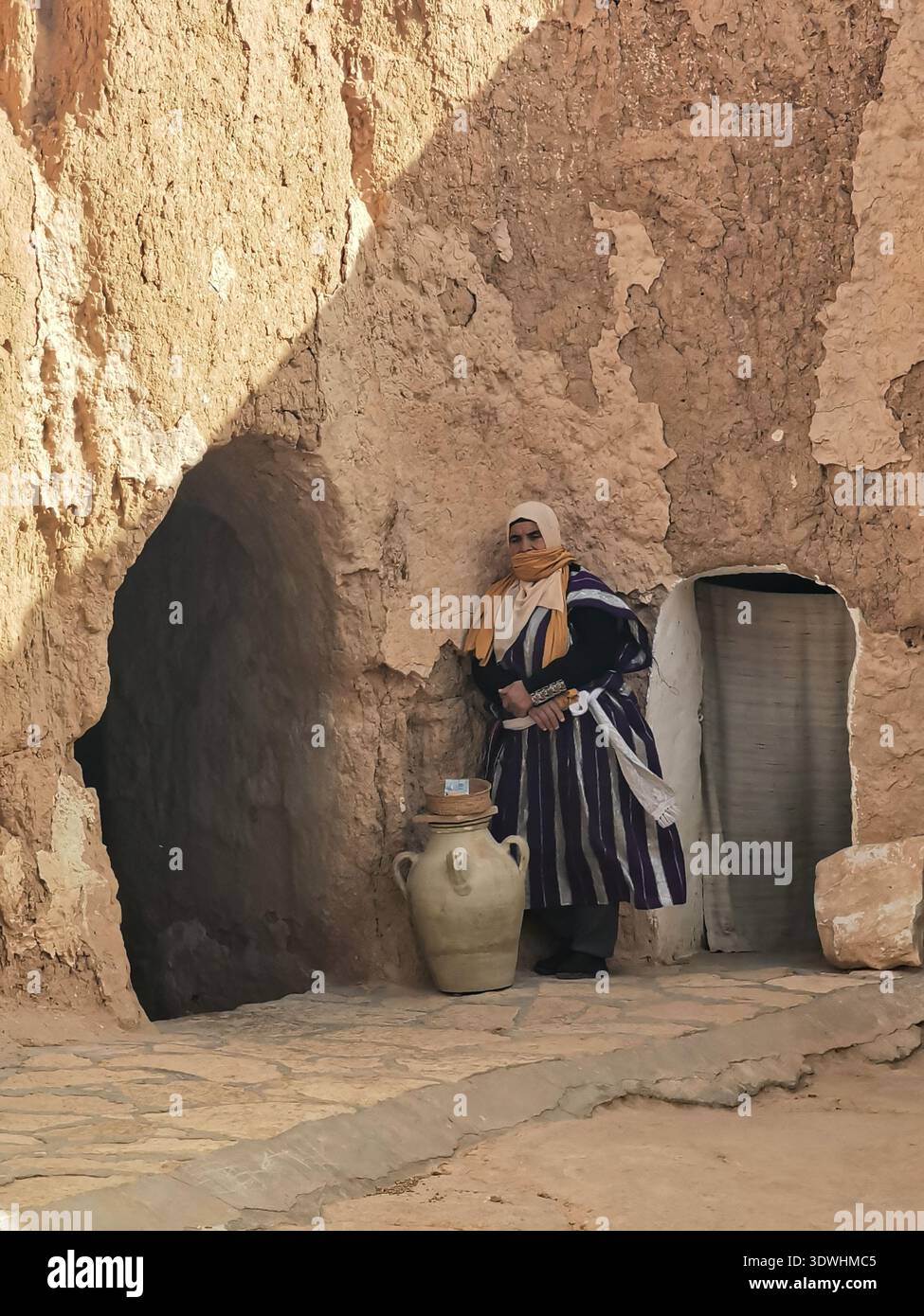 Berberfrauen öffnen ihr unterirdisches Höhlenhoglodytenhaus für Touristen in Matmata, Tunesien, und bieten Honig, Olivenöl und Tabuuna-Brot an. Stockfoto