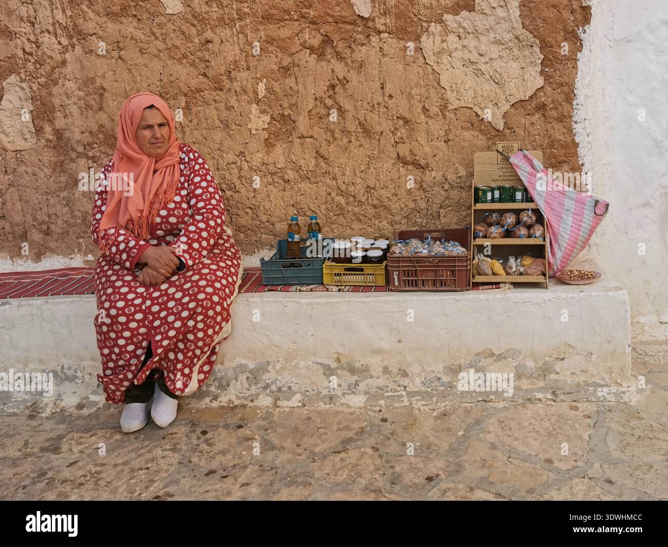 Berberfrauen öffnen ihr unterirdisches Höhlenhoglodytenhaus für Touristen in Matmata, Tunesien, und bieten Honig, Olivenöl und Tabuuna-Brot an. Stockfoto