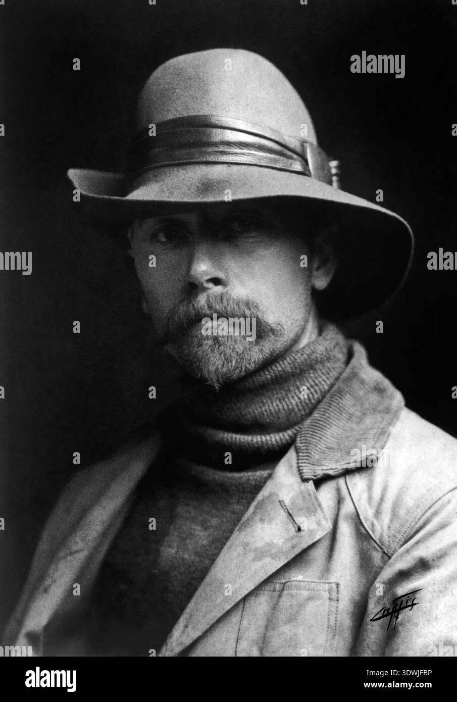 Dieses graue Selbstporträt von Edward S. Curtis aus der Zeit um 1899 fängt den berühmten Fotografen ein, der den Betrachter mit einem nachdenklichen Ausdruck direkt anblickt. Er trägt einen weiträumigen Filzhut, einen Rollkragen-Pullover und eine Jacke mit Cordkragen, ein unverkennbarer Look für den Künstler, der das Leben der Ureinwohner ausführlich dokumentiert. Stockfoto