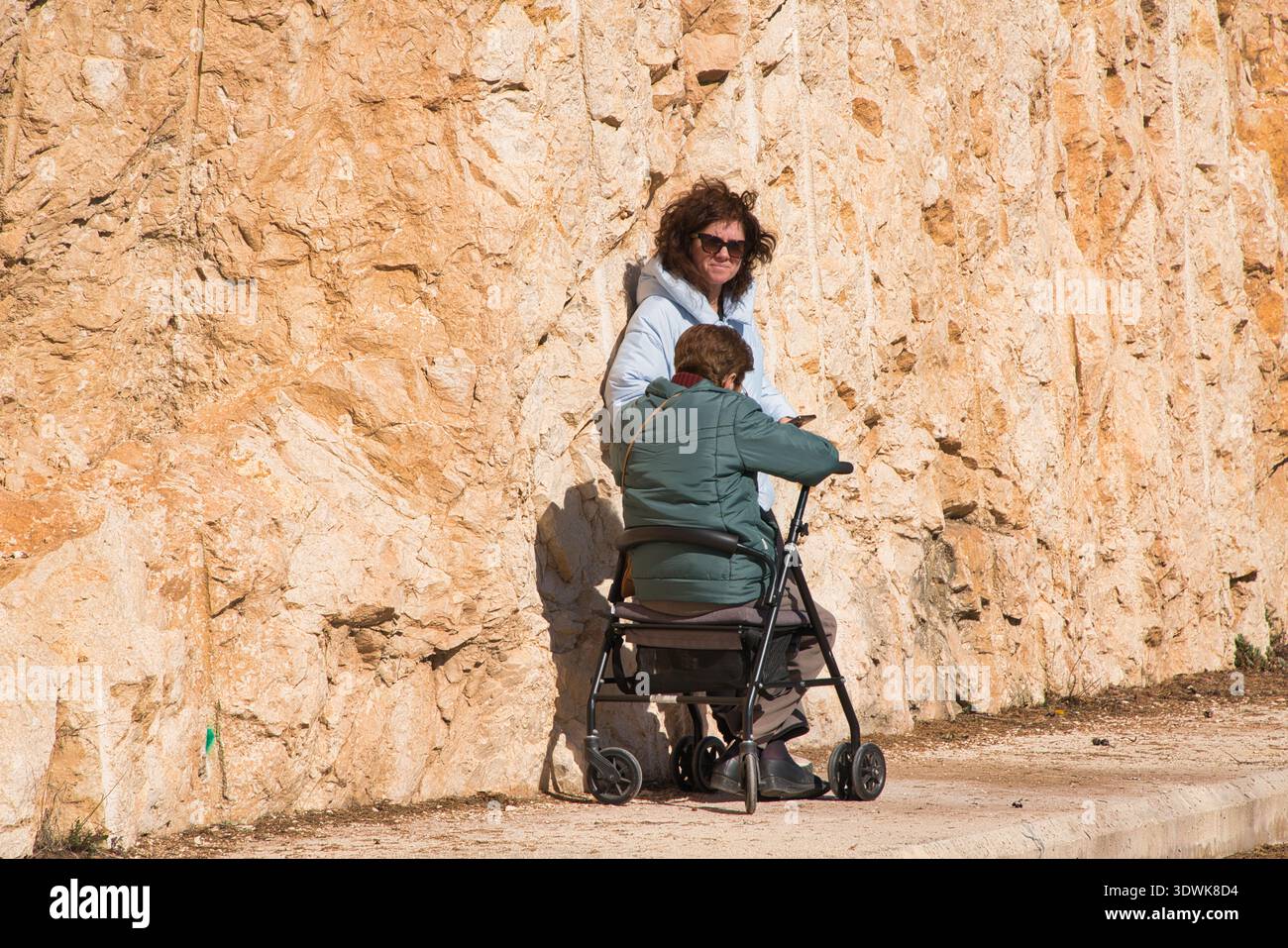 Eine Frau, die Sonnenbrille trägt, mit einem älteren Verwandten. Stockfoto