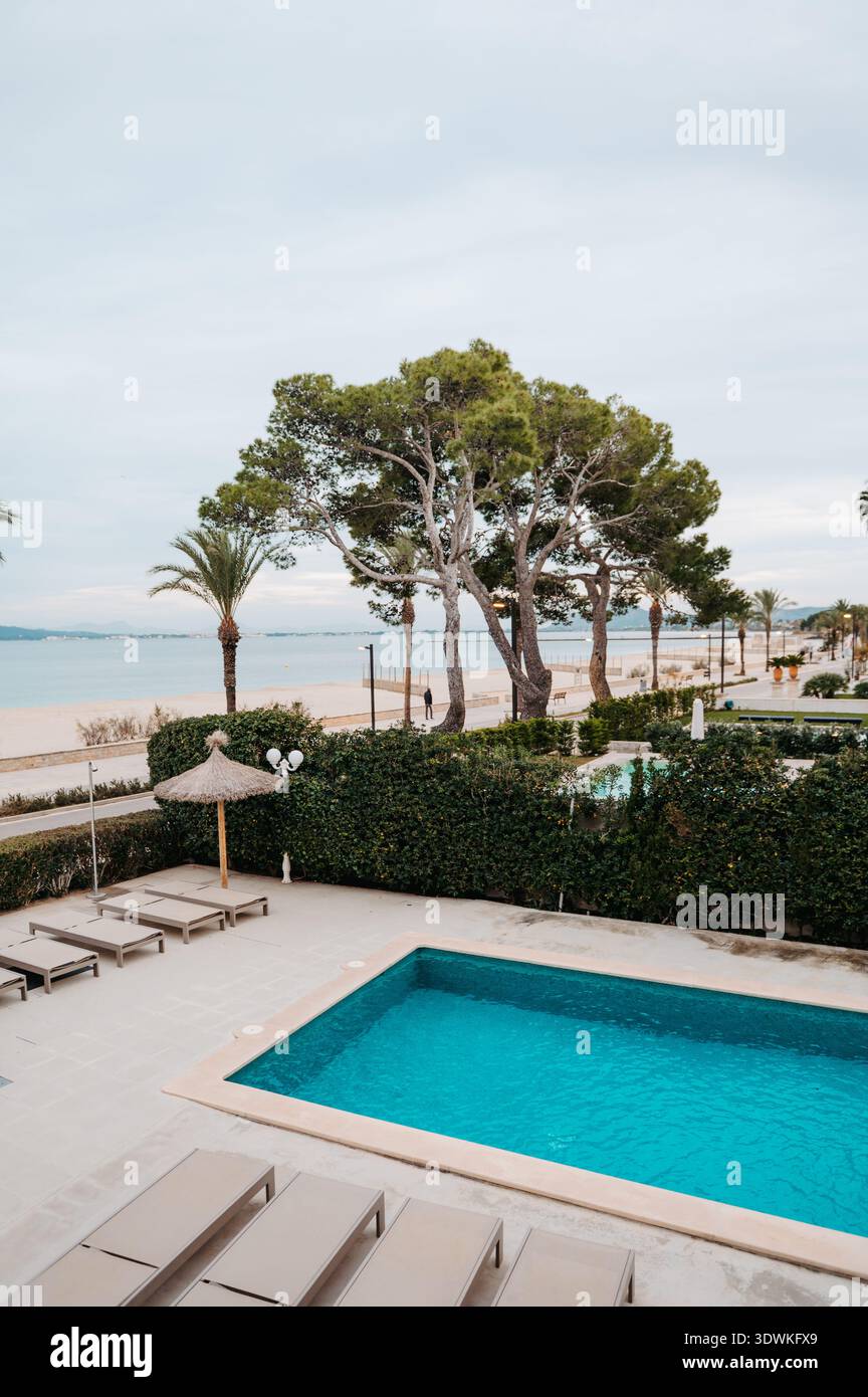 Hotelpool am Strand mit Blick auf den Strand von Port de Pollenca, Mallorca Stockfoto