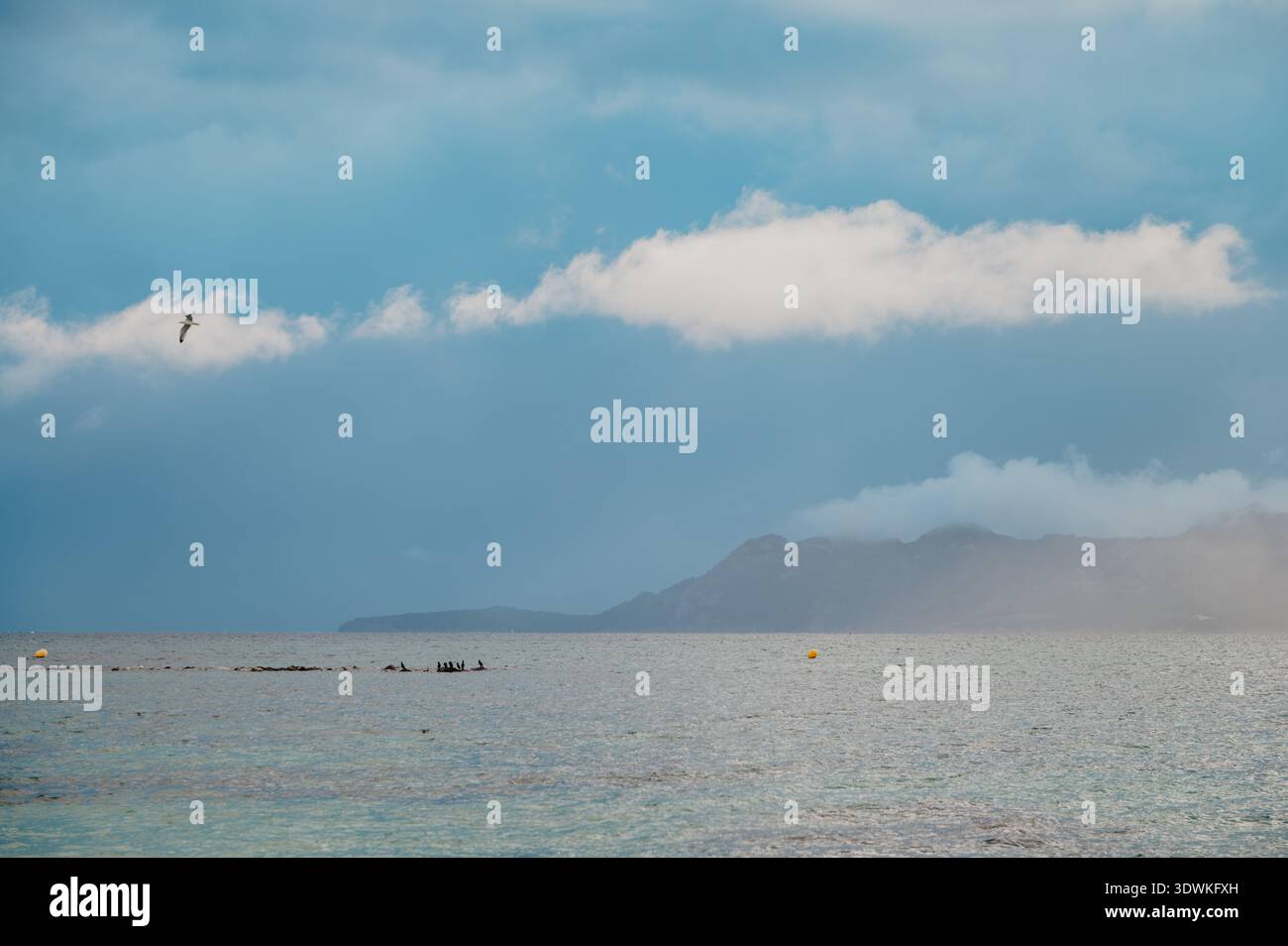 Ferne Berge und dramatische Wolken am Port de Pollenca, Mallorca Stockfoto