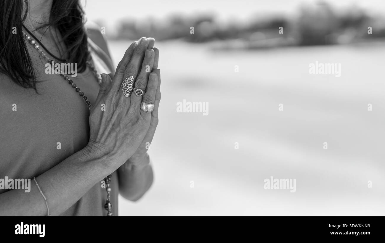 Eine heitere Frau übt Achtsamkeit mit Händen in Anjali Mudra Stockfoto