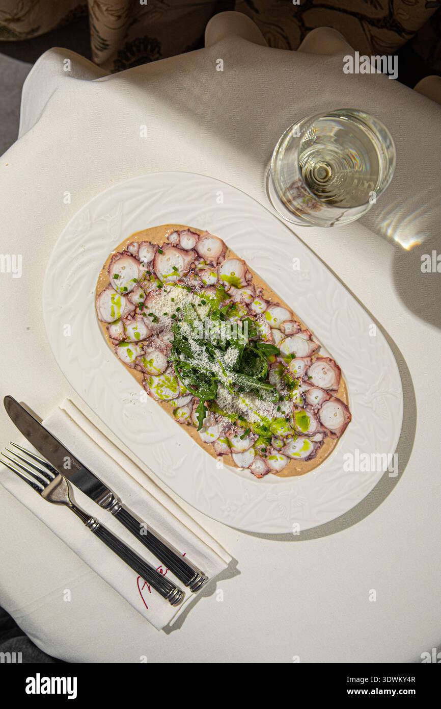 Octopus carpaccio mit Rucola und Parmesan Stockfoto