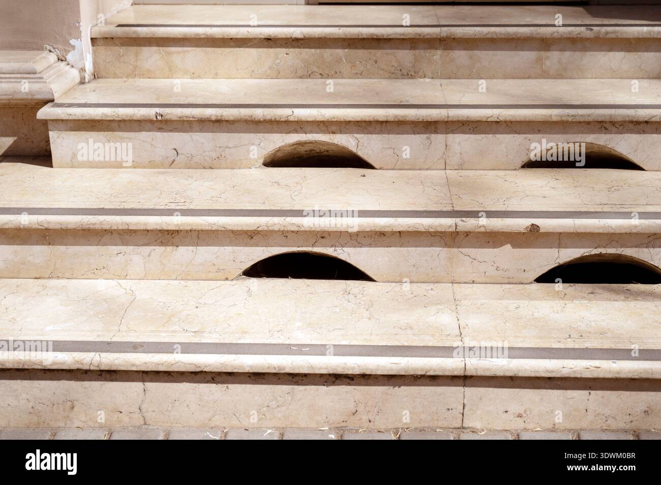 Polierte Marmorstufen eines großen Eingangs mit dekorativen Lüftungslöchern. Konzept von luxuriösen Innenmaterialien, robuster Steinkonstruktion und ELEL Stockfoto