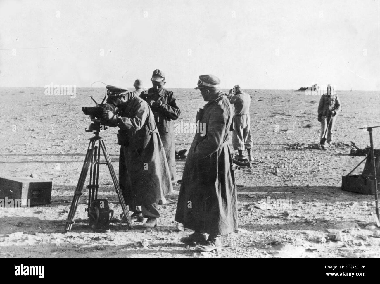 Marschall Erwin Rommel beobachtet das deutsche Einsatzgebiet mit seinem Flakfernrohr DF 10x80 Flugabwehrfernglas. Deutsche Offiziere sind in der Nähe sichtbar. Stockfoto