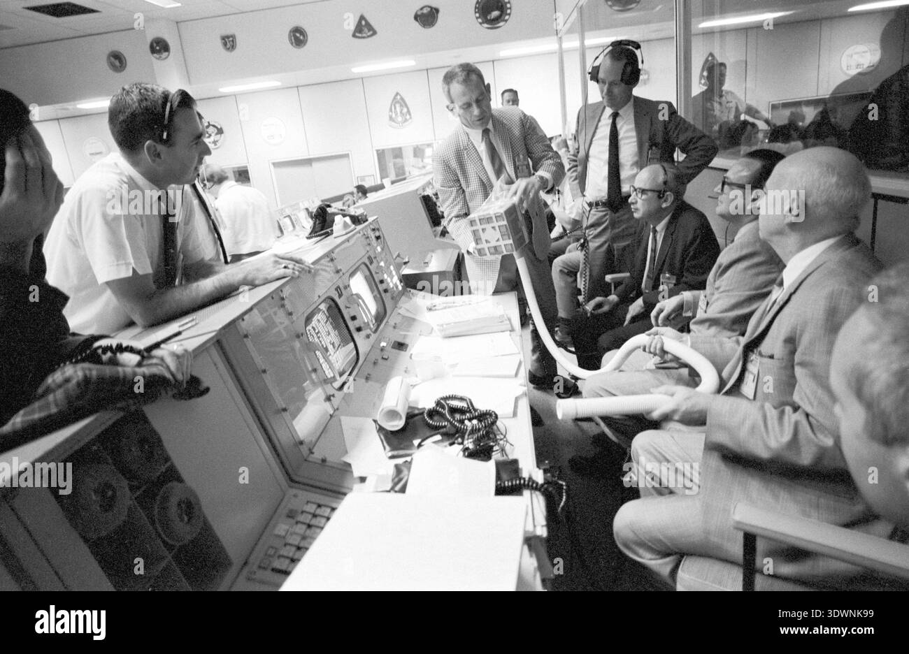 Ab April 1970 wird Deke Slayton in Mission Control gesehen und demonstriert den provisorischen Adapter, der entwickelt wurde, um quadratische Lithium-Hydroxid-Kanister des Command Moduls mit dem Apollo 13 Mondmodul zu verbinden. Diese kritische Improvisation wurde durchgeführt, um überschüssiges Kohlendioxid zu entfernen und das Überleben der Besatzung nach dem berüchtigten Notfall während des Fluges zu sichern. Stockfoto