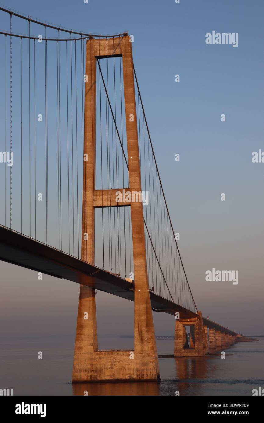 Sonnenaufgang - Segeln Sie unter der Großen Belt-Brücke (Storebæltsbroen), der Ostbrücke, die die dänischen Inseln Seeland und Funen verbindet. Stockfoto